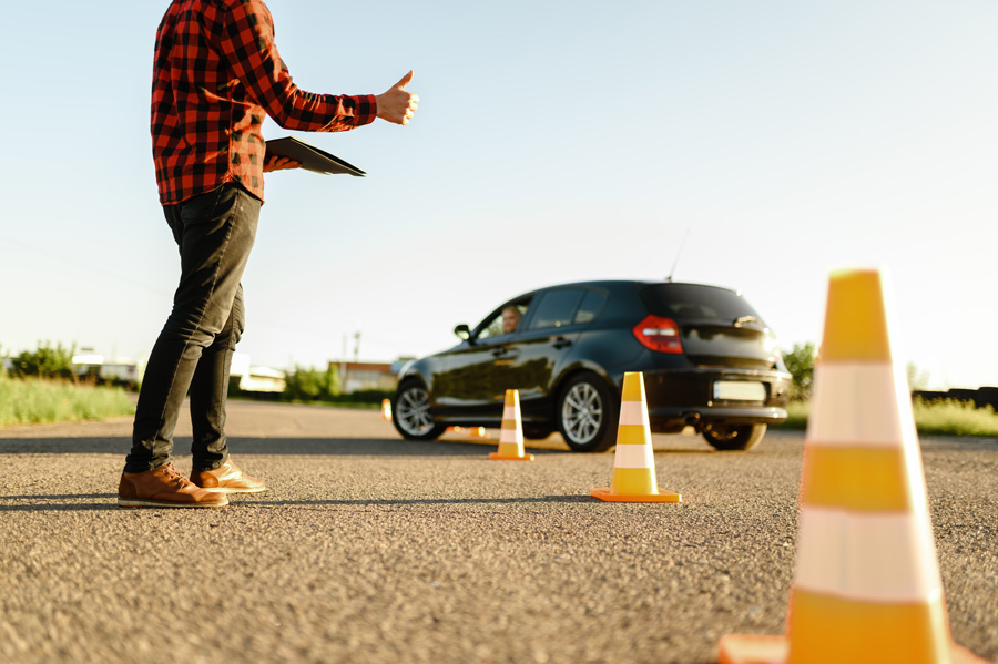 instructor-helps-female-student-drives-cones-lesson-driving-school